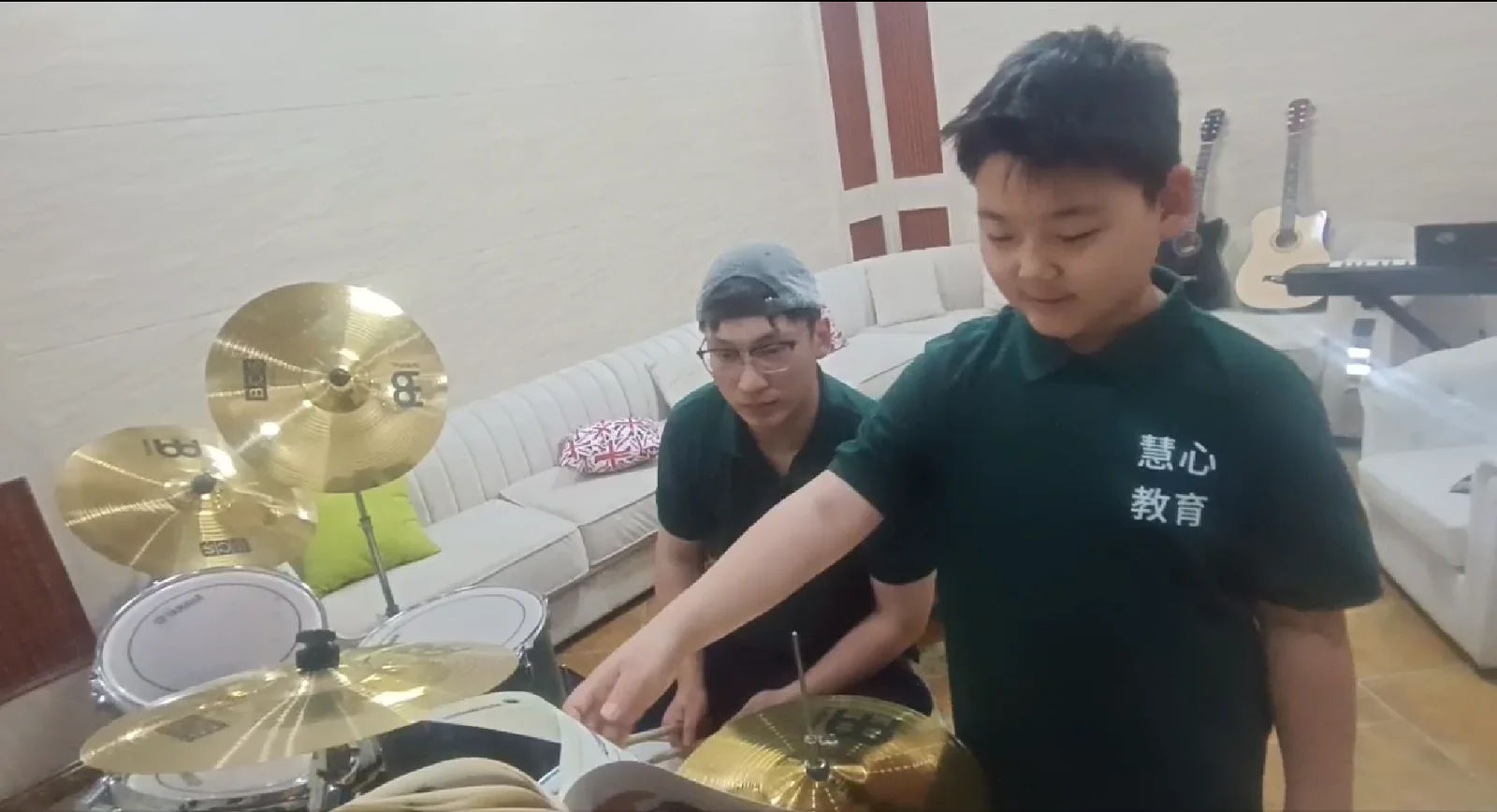 学生在导师陪伴下练习架子鼓
